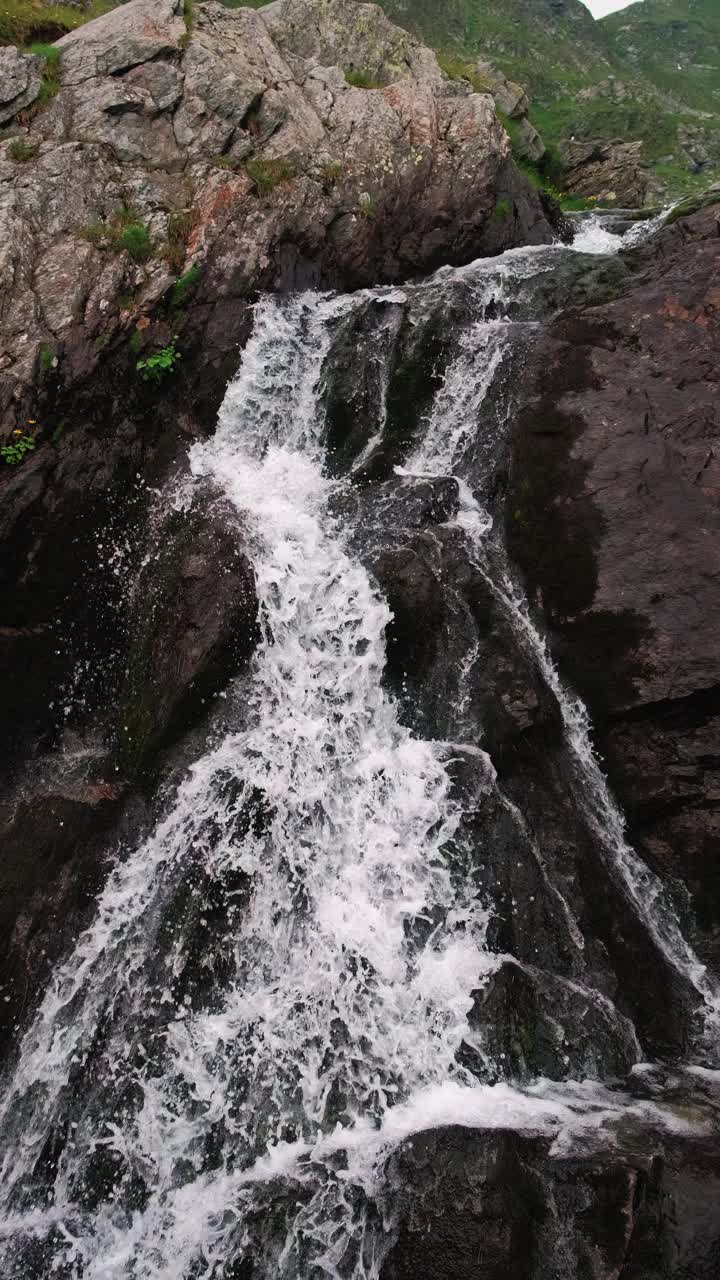 碧绿的山景中，壮观的瀑布从岩石上流下，营造出一种宁静的自然景观视频素材