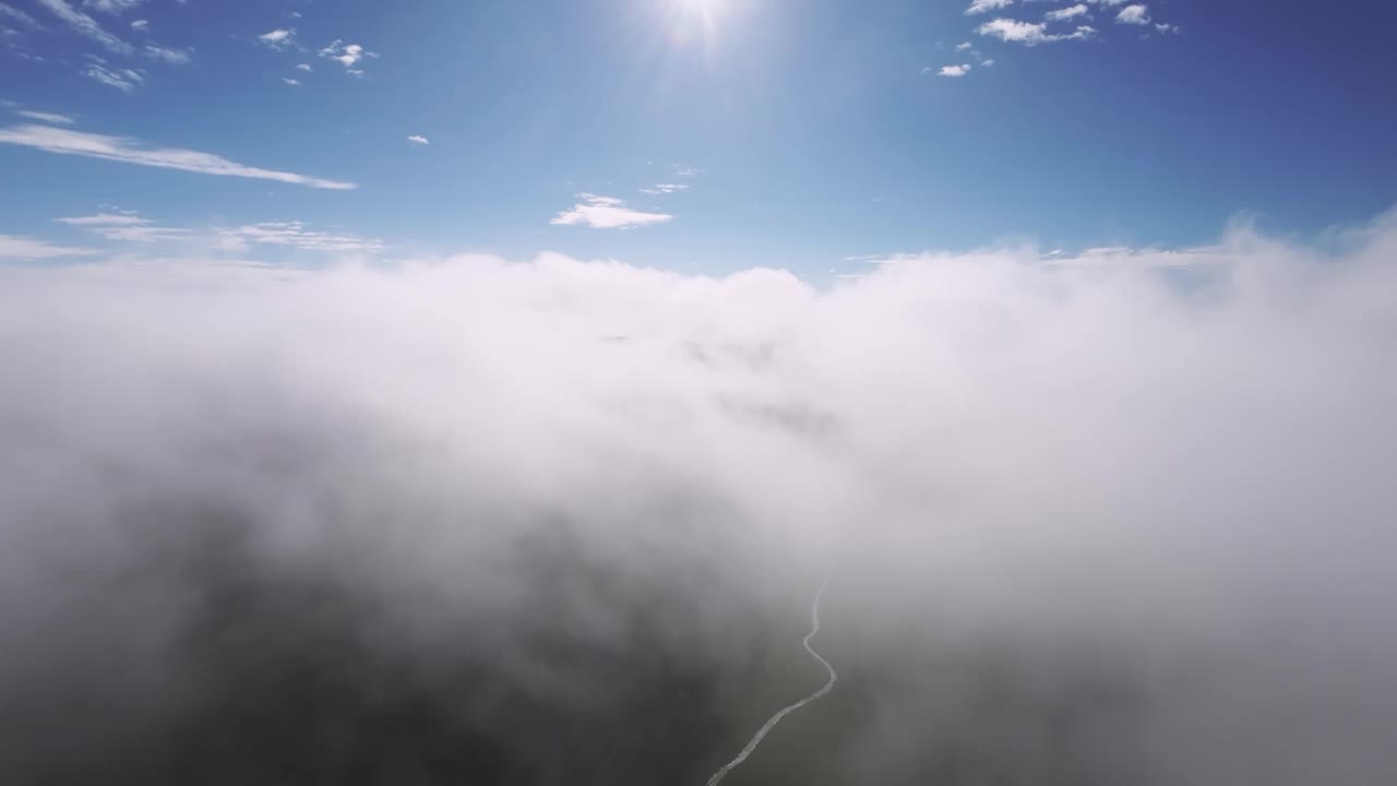 在山区云层上方飞行的彩虹鸟瞰图。日落时，山上的彩虹伴着云彩视频素材