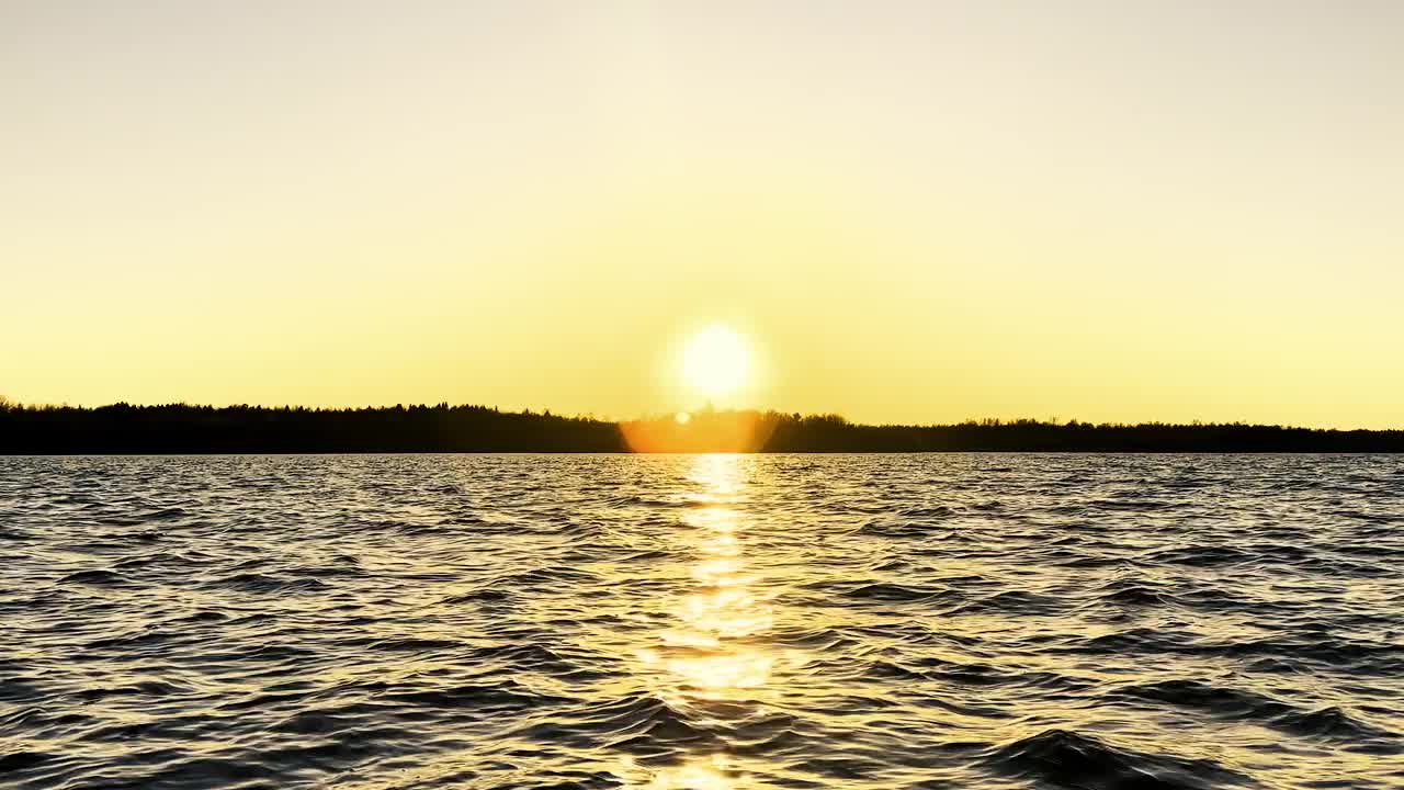 水表面。日落天空背景的视图。湖面上金色的夕阳。清澈的水质感。景观。水与反射运动视频下载