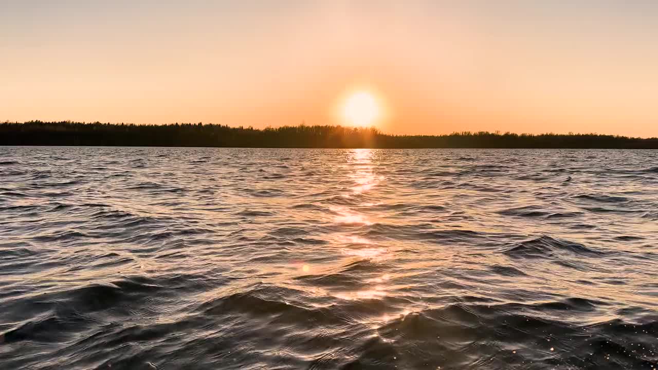 水表面。日落天空背景的视图。湖面上金色的夕阳。清澈的水质感。景观。水与反射运动视频素材