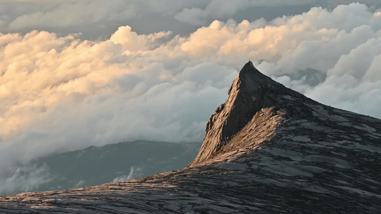 基纳巴卢山标志性的南峰(3900米)的壮观景色被阳光照亮。基纳巴卢山是东南亚最高的山之一。视频素材