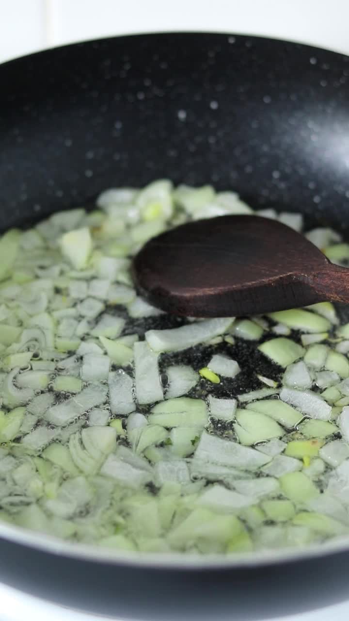 在锅里用热食用油煎洋葱末，特写视频下载