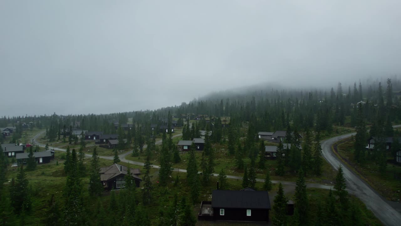 空中平移拍摄的豪华滑雪小屋在Sjusjøen，挪威在一个黑暗的雨夜视频素材