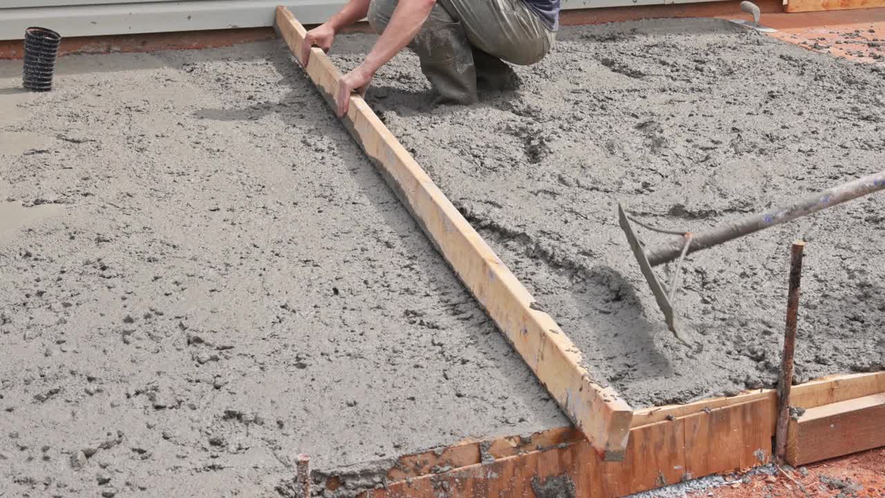 混凝土工程建筑工人使用特殊工具来平整水泥、地基、砂浆和找平板。视频素材