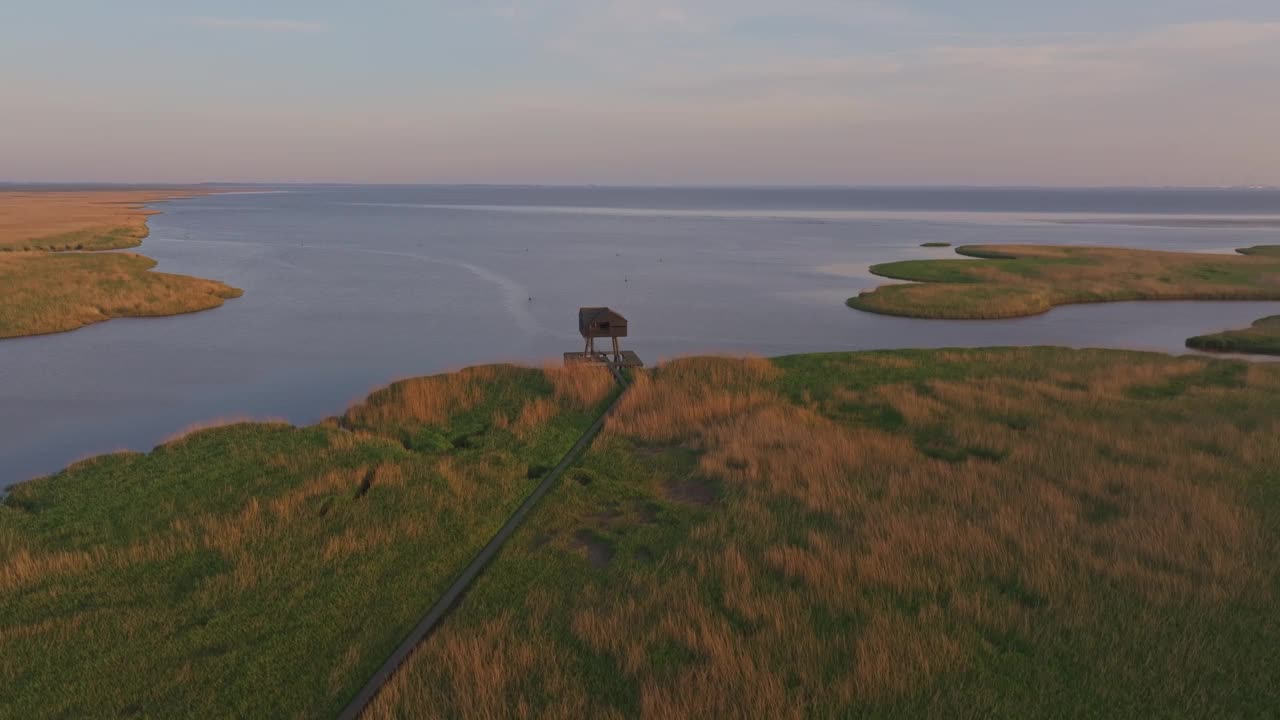 鸟瞰荷兰瓦登海日出时的观鸟者小屋。视频素材