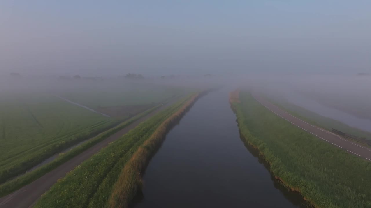 荷兰，雾蒙蒙的河流和绿色田野的鸟瞰图。视频素材