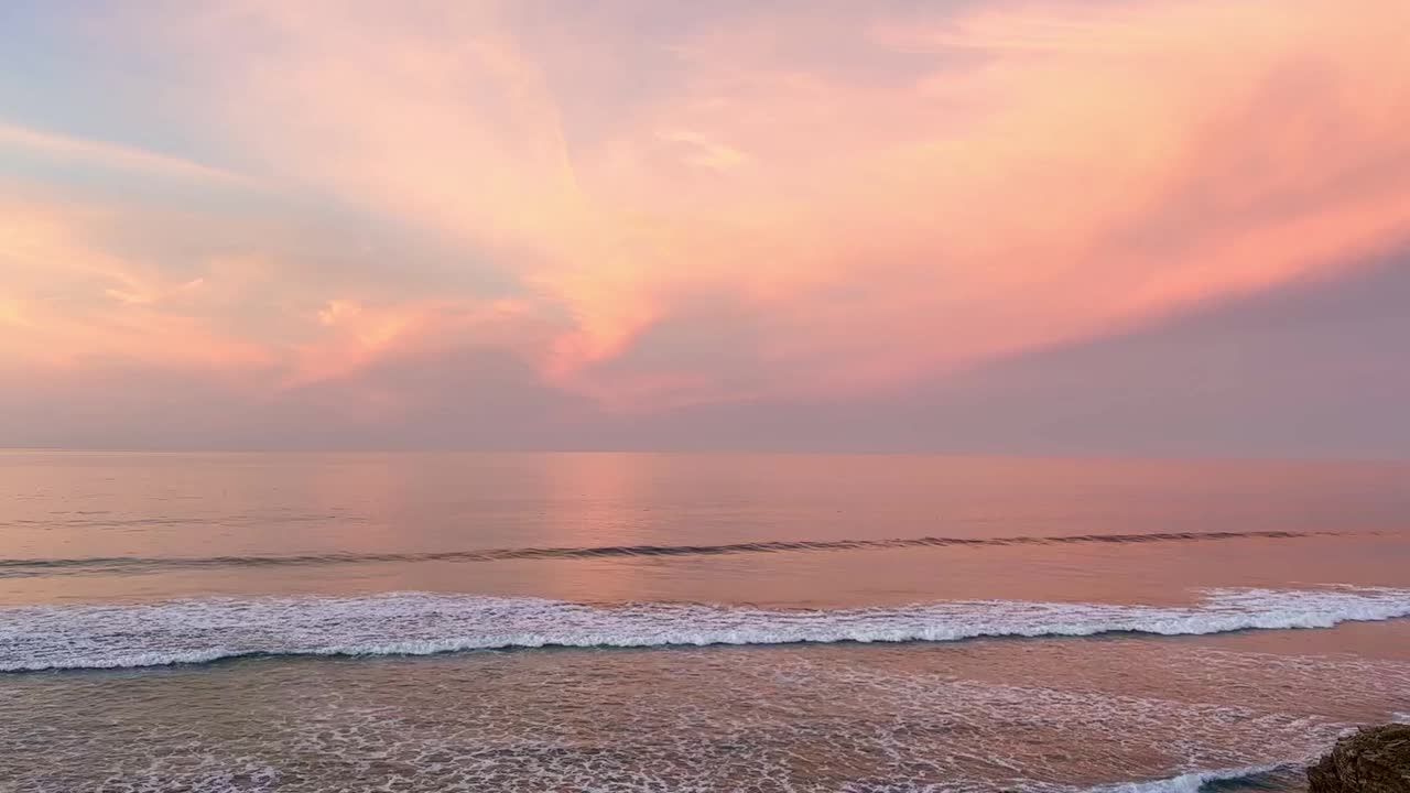 天空是粉红色的，海洋是平静的视频素材