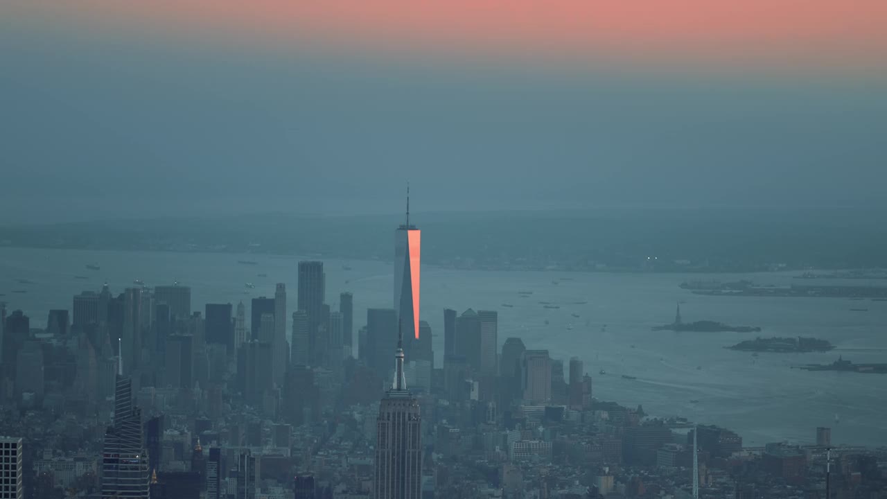 日落时从直升机上航拍的纽约。曼哈顿市中心摩天大楼和桥梁的鸟瞰图。在金融区和哈德逊河上空飞行。视频下载