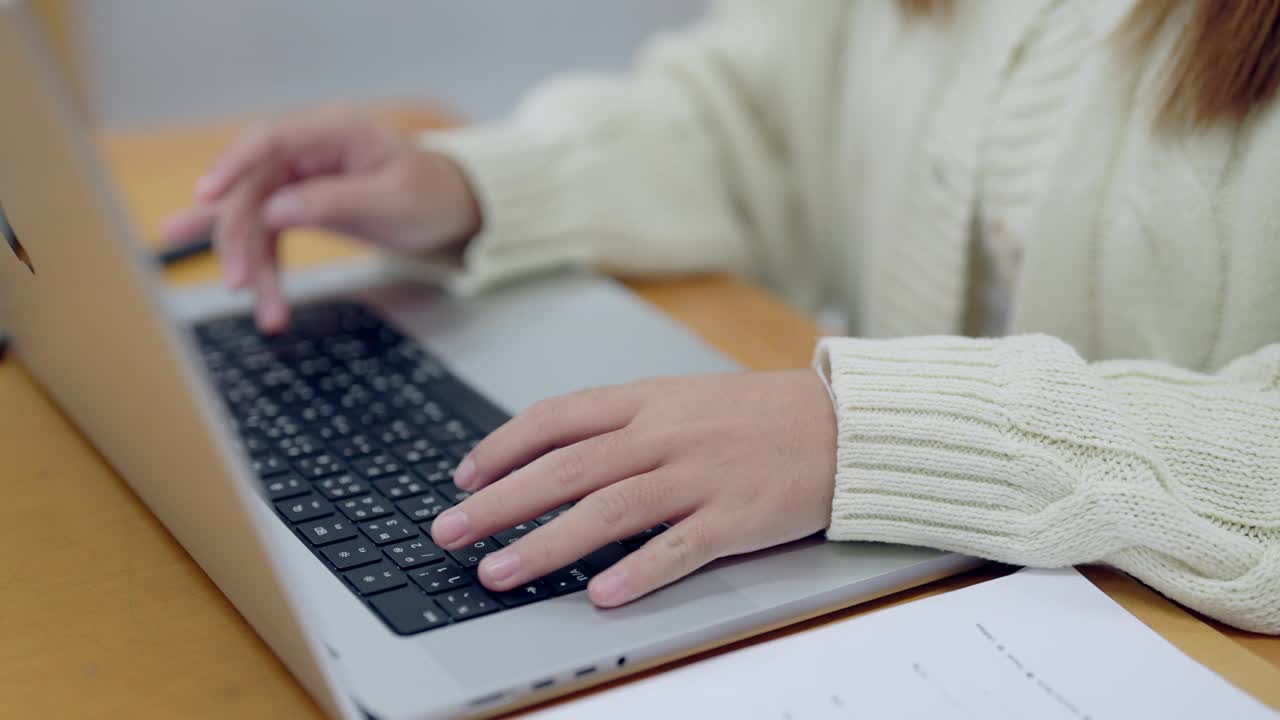 一个女人正在用笔记本电脑打字，她的手放在键盘上视频素材