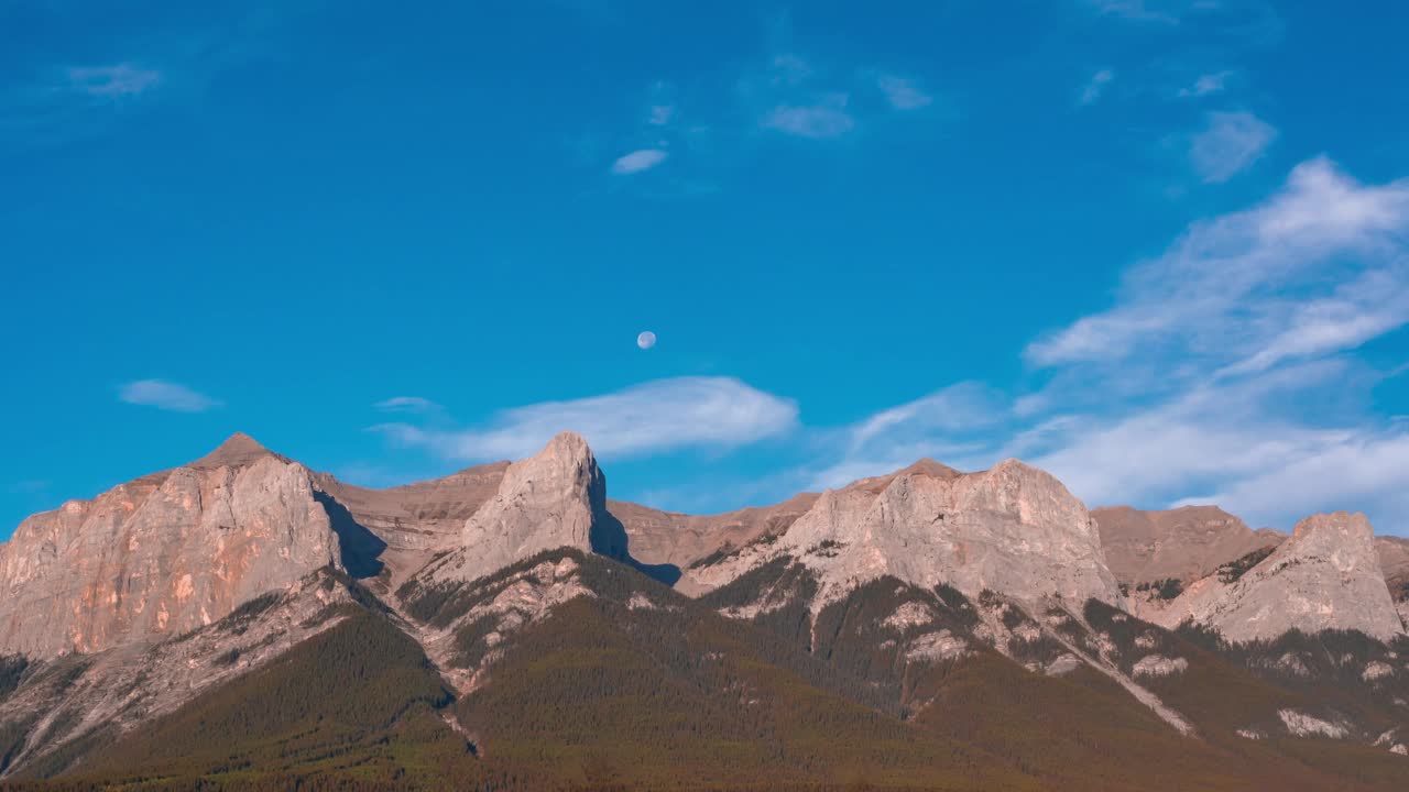 自然风光与落基山脉和美丽的蓝天景观4k延时镜头。山峰高耸在空中。柔和的白云在柔和的蓝色空间中移动视频素材