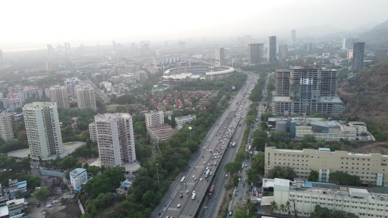 空中无人机视图的新孟买天际线在Nerul和多车道国家高速公路上的交通流量-锡安潘维尔高速公路或孟买萨塔拉高速公路从无人机的视角在一个抽象的视频片段。视频素材