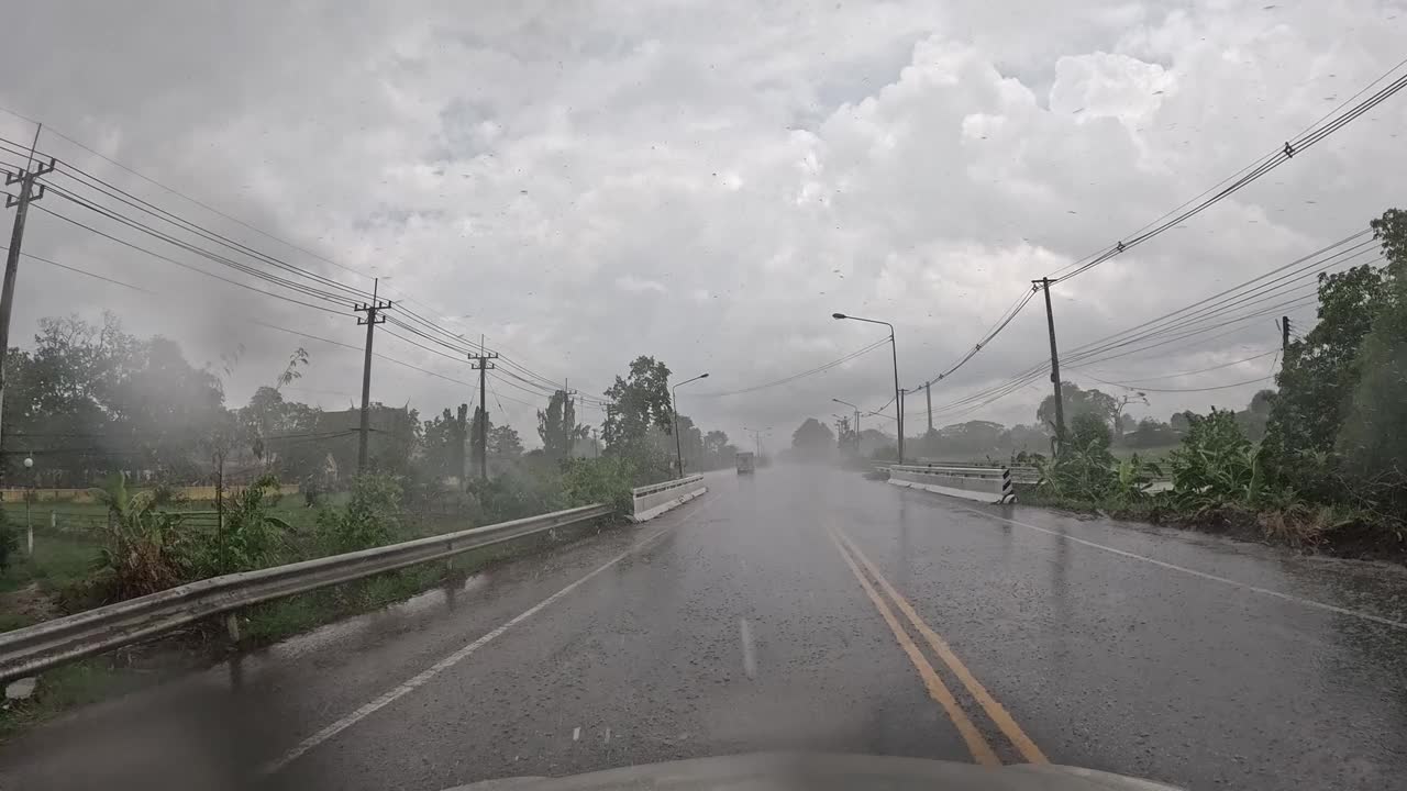 汽车行驶在泰国乡村道路上，那里下着暴雨。视频下载
