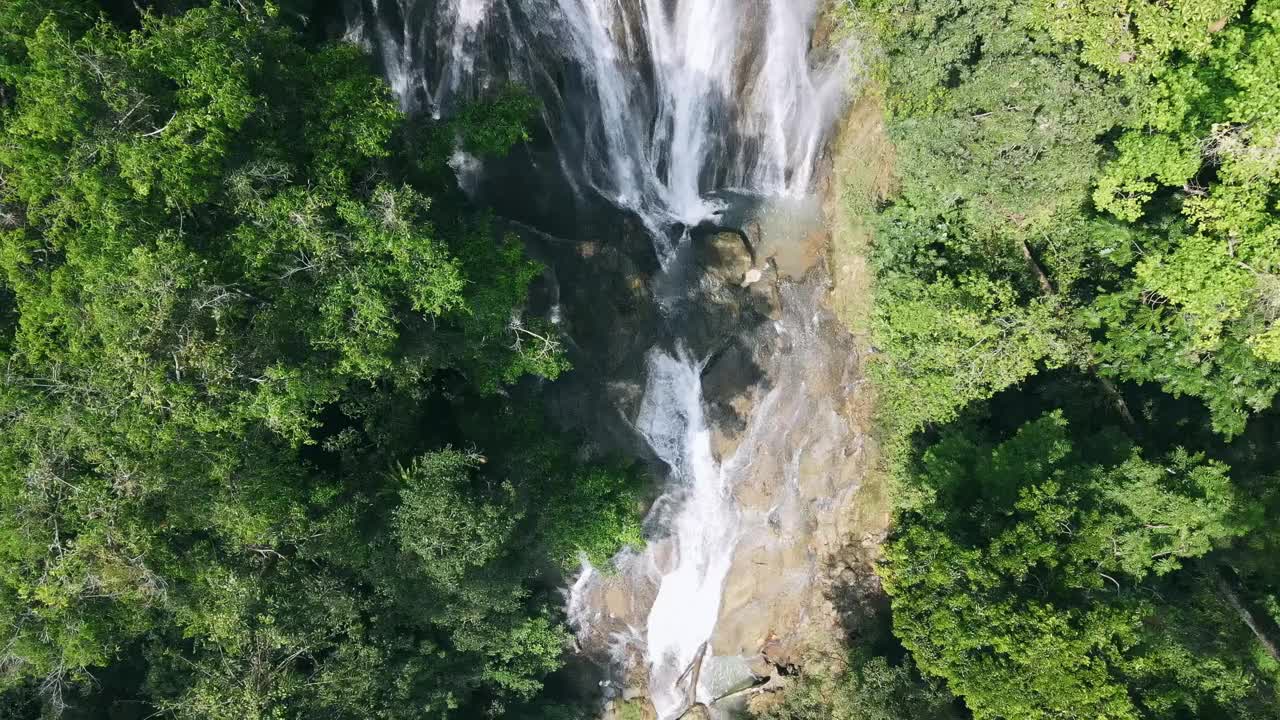 瀑布从悬崖的裂缝中喷涌而出，在雨林中创造了一个壮观的场景，迷人的原始自然美景。视频素材