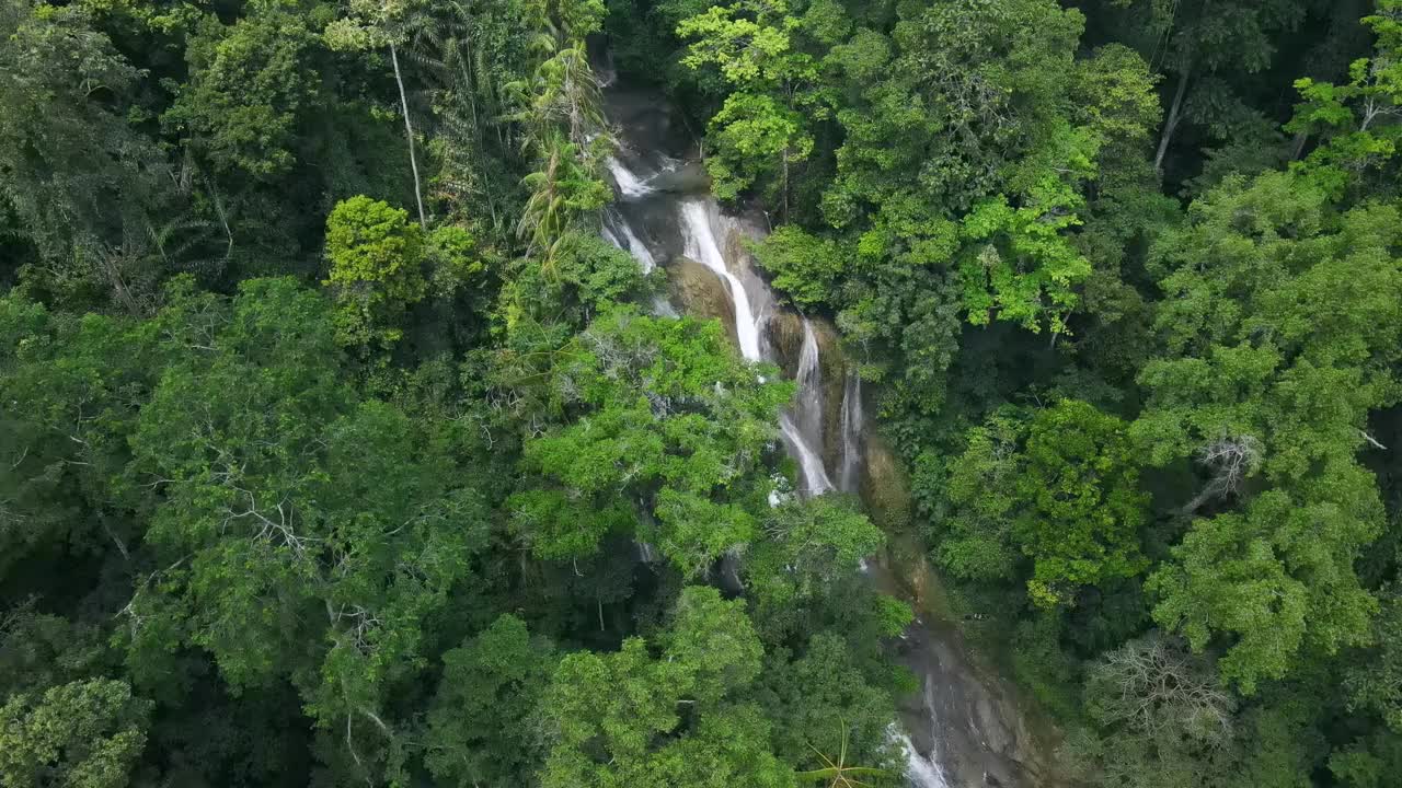 迷人的瀑布在雨林的自然美景中创造了完美的场景。视频素材