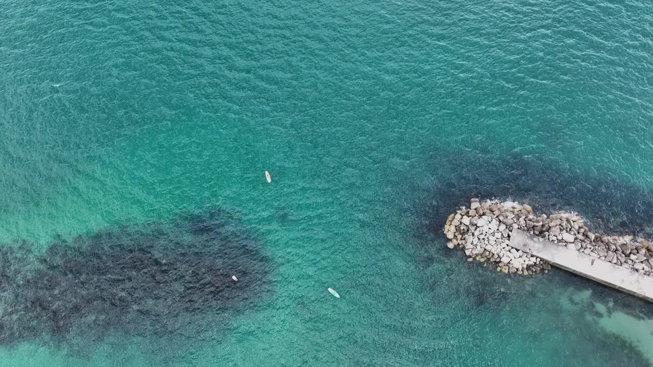 阳光明媚的日子里，海滨城市熙熙攘攘的海滩鸟瞰图视频下载