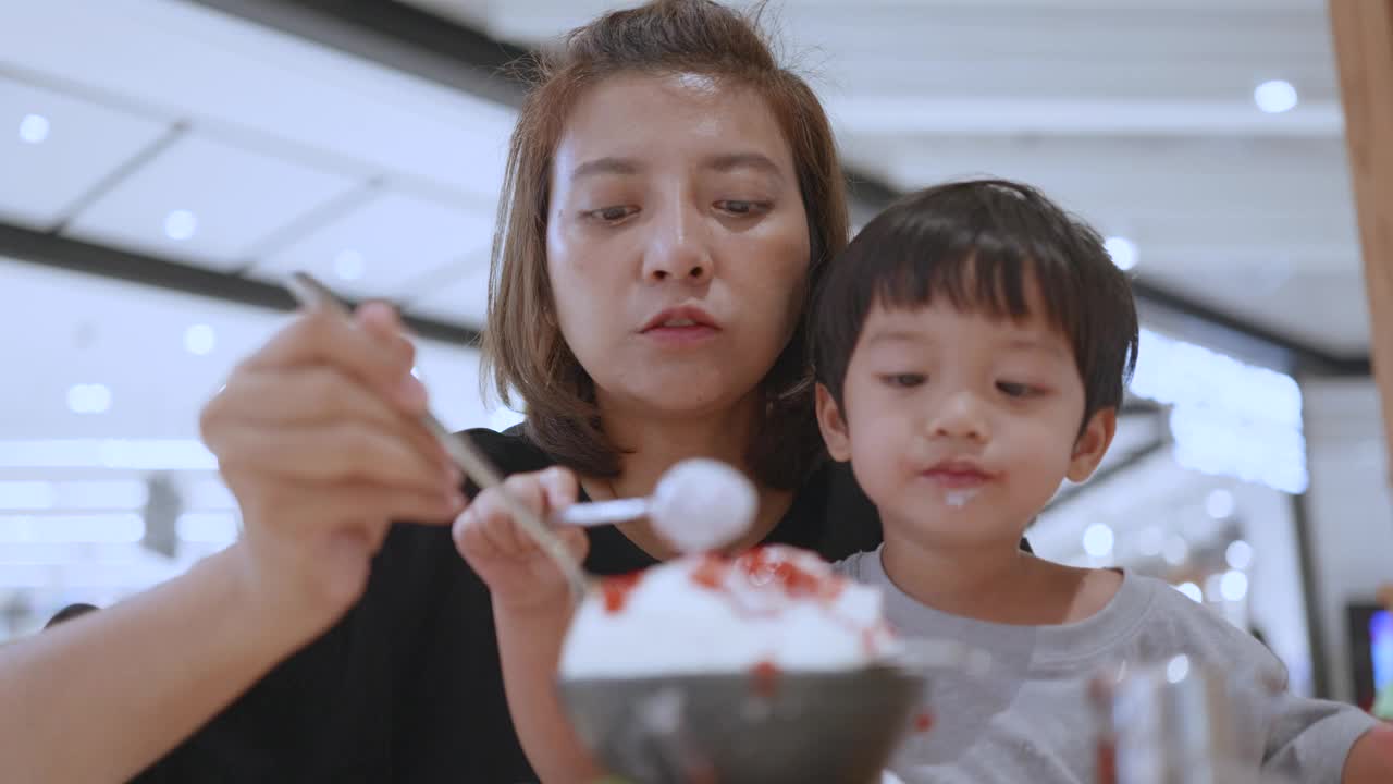 快乐的亚洲母子吃着草莓冰淇淋。韩式bingsu。视频素材