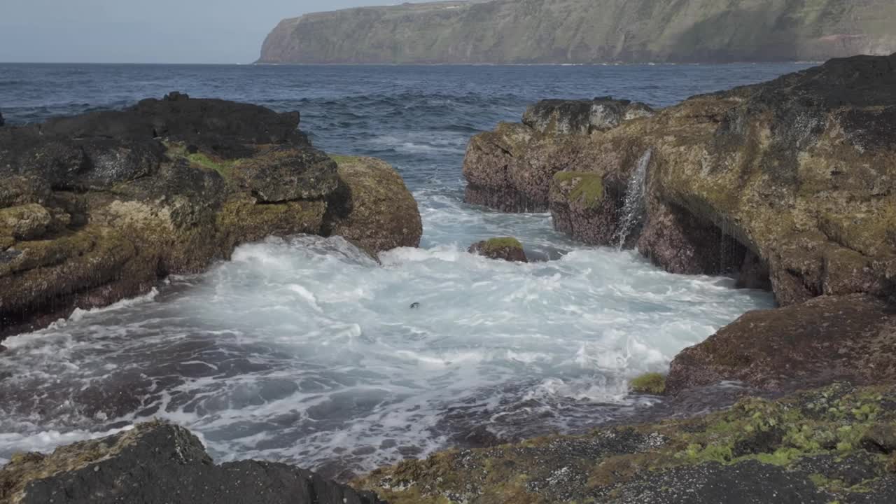 海浪冲击着莫斯泰罗斯的岩石悬崖，圣米格尔与远处的山丘，充满活力和活力视频素材