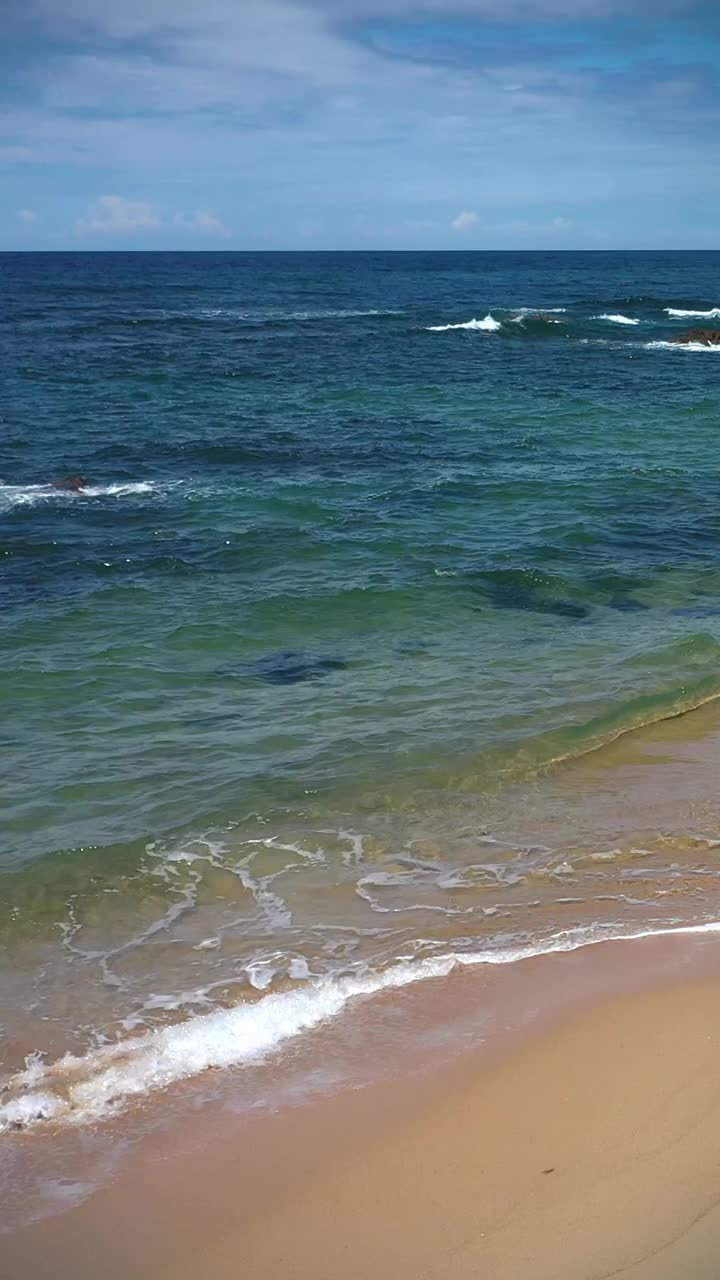 海浪，沙滩和岩石在海滩，背景与复制空间视频下载