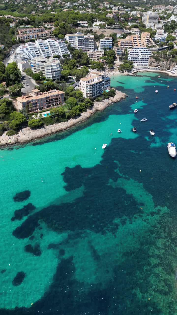 西班牙马略卡岛，伊莱塔斯海滩上清澈碧绿的海水和日光浴者的鸟瞰图视频素材