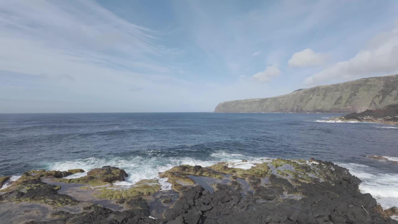 莫斯泰罗斯的岩石海岸线，圣米格尔蓝天下的云朵散落，海浪拍打着海岸视频素材