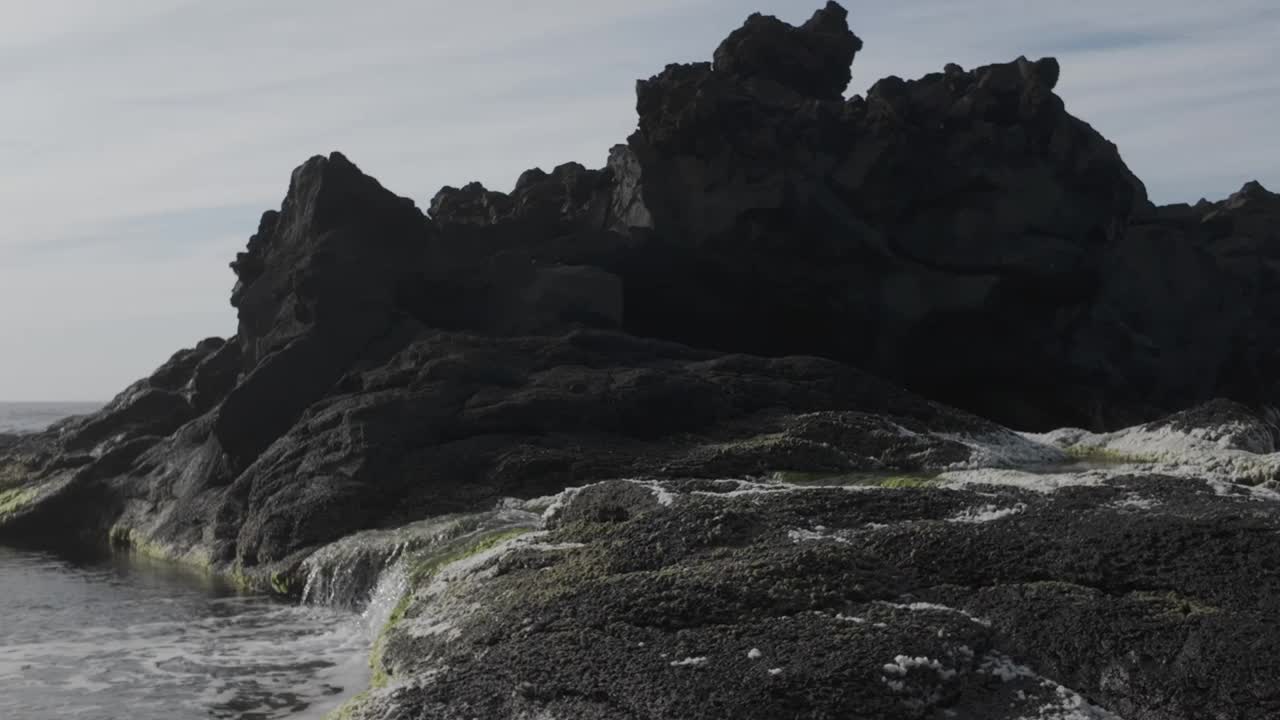 崎岖的火山岩在莫斯蒂罗斯海滩，圣米格尔在D-log，捕捉一个戏剧性的海景视频素材