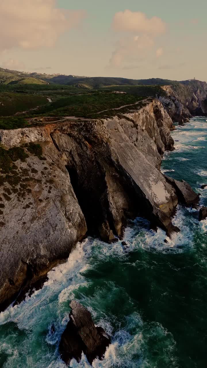 鸟瞰图的波涛和陡峭的岩石形成沿海岸。葡萄牙辛特拉附近普拉亚达阿德拉加海滩的大西洋海岸线视频素材