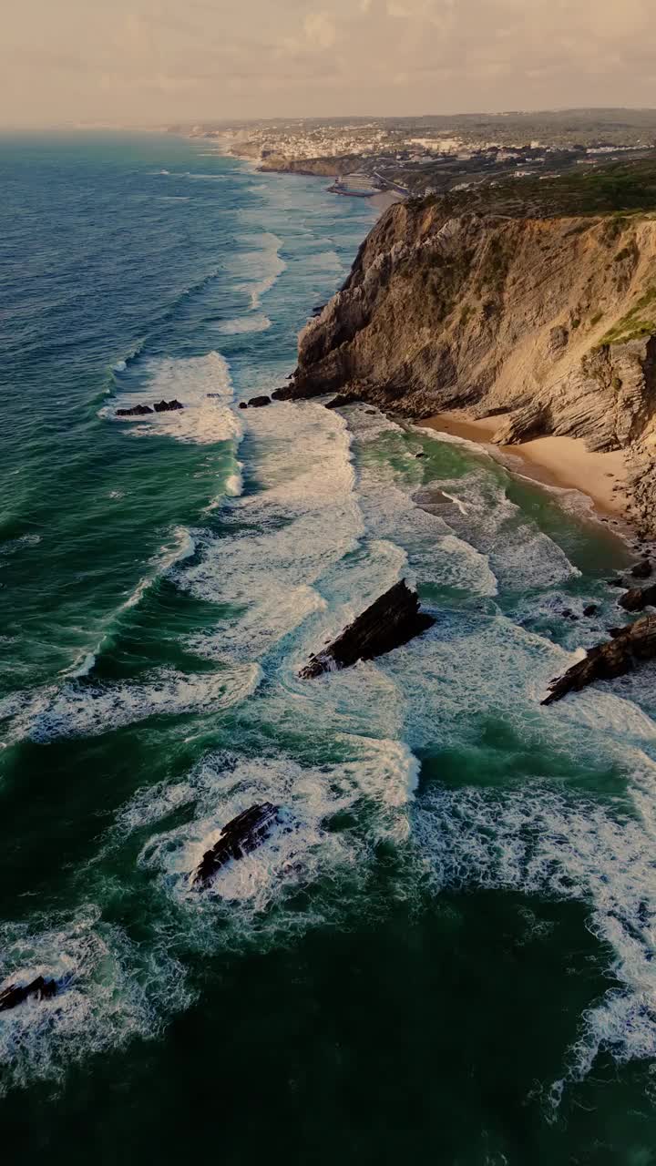 鸟瞰图的波涛和陡峭的岩石形成沿海岸。葡萄牙辛特拉附近普拉亚达阿德拉加海滩的大西洋海岸线视频素材