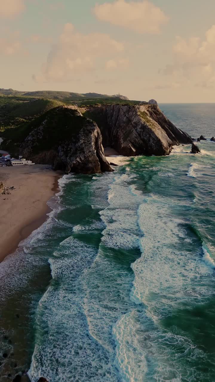 鸟瞰图的波涛和陡峭的岩石形成沿海岸。葡萄牙辛特拉附近普拉亚达阿德拉加海滩的大西洋海岸线视频素材