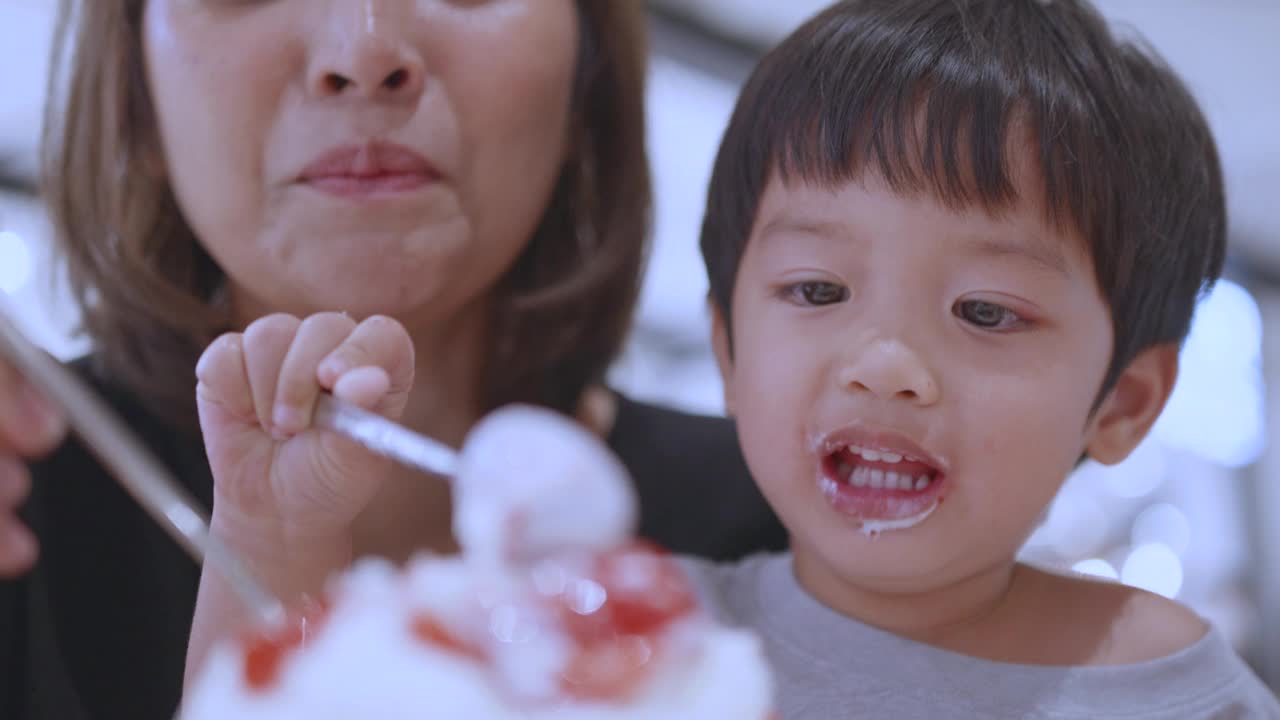 快乐的亚洲母子吃着草莓冰淇淋。韩式bingsu。视频素材