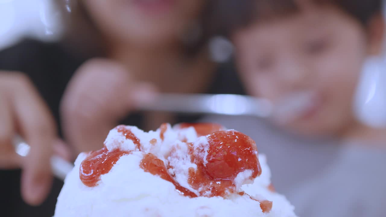 快乐的亚洲母子吃着草莓冰淇淋。韩式bingsu。视频素材