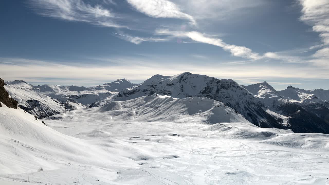 令人惊叹的时间跨度在雪山Ecrins，法国。晴朗的蓝天充满了白色，被阳光和引人注目的云照亮。以阿尔卑斯山的自然、冒险和旅行为背景视频素材