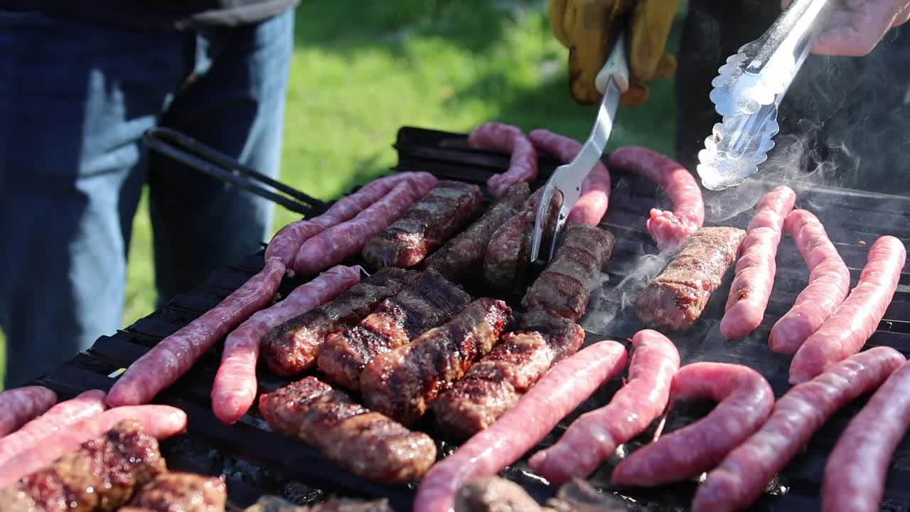 一群人在烤架上烤肉香肠当午餐。-特写镜头视频素材