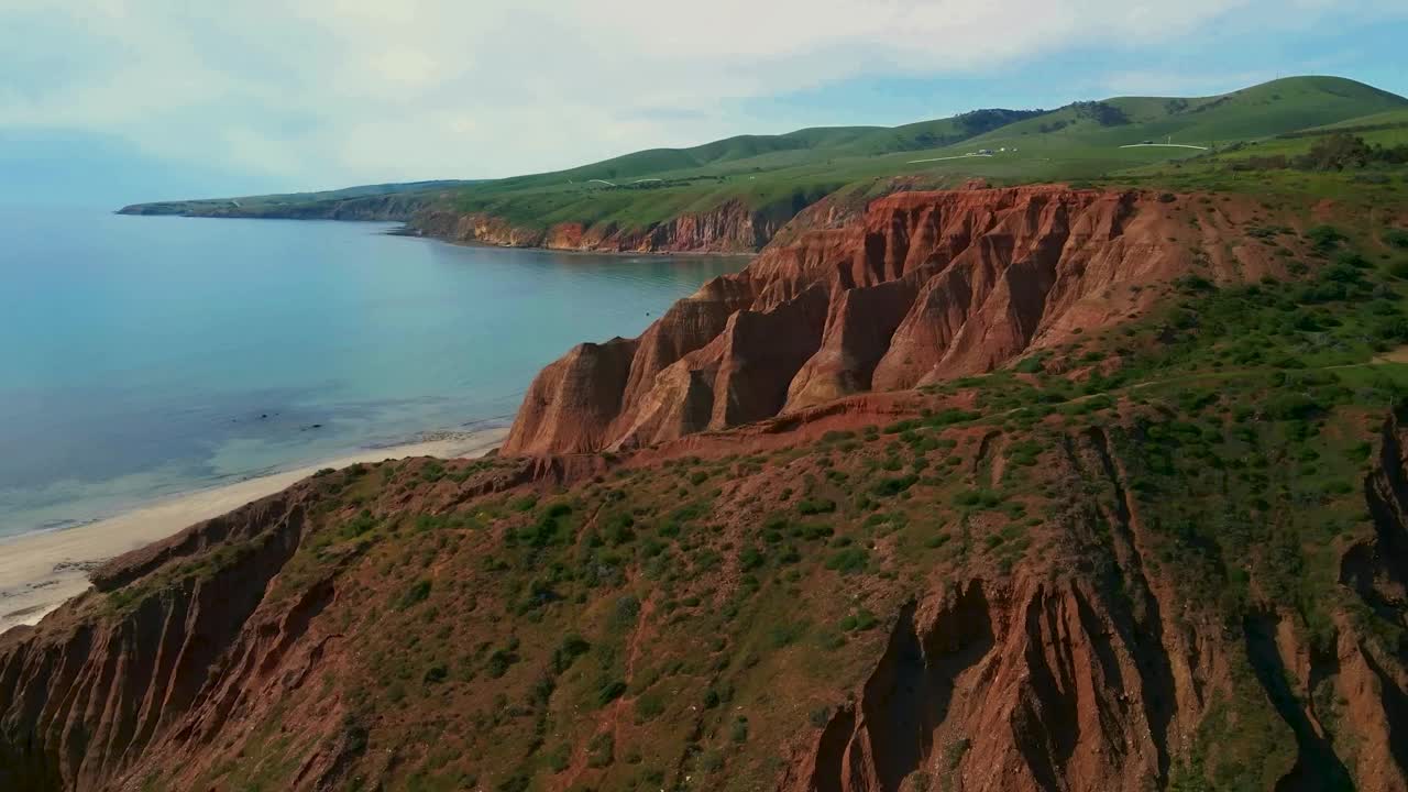 雄伟的海岸悬崖与充满活力的红土俯瞰美丽的蓝色海洋风景视频素材