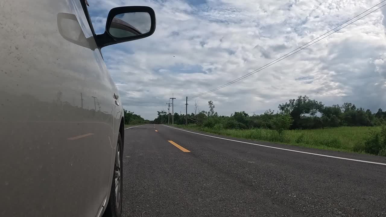 延时;一辆汽车经过一群穿过乡间小路的棕色奶牛时的侧视图。视频素材