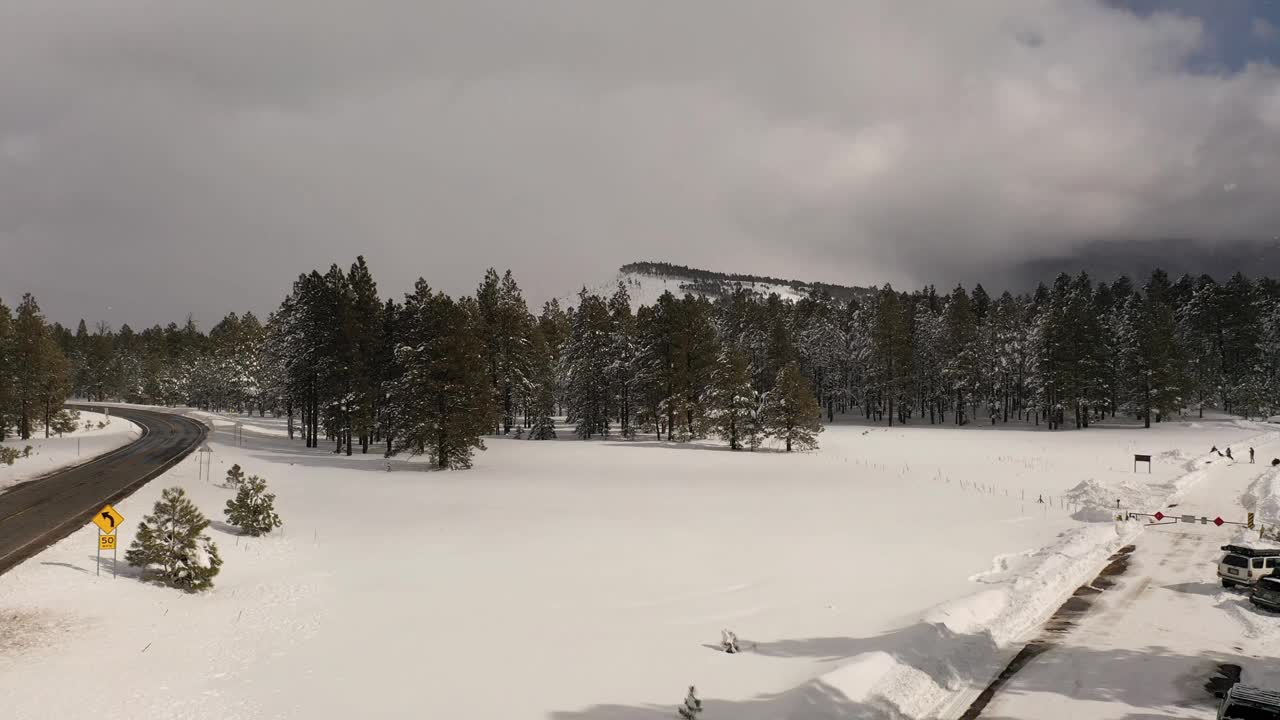 飞越白雪覆盖的荒野，松树和高山。冬天的仙境。视频素材