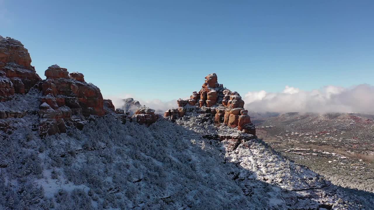 飞越云层，飞越亚利桑那州塞多纳的冬季仙境，暴风雪过后，红色的岩石被新雪覆盖。视频素材