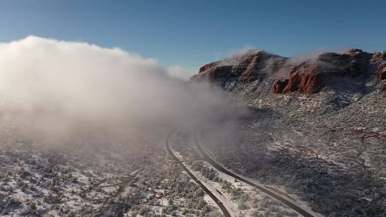 飞越云层，飞越亚利桑那州塞多纳的冬季仙境，暴风雪过后，红色的岩石被新雪覆盖。视频素材