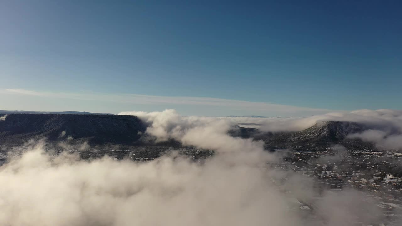 飞越云层，飞越亚利桑那州塞多纳的冬季仙境，暴风雪过后，红色的岩石被新雪覆盖。视频素材