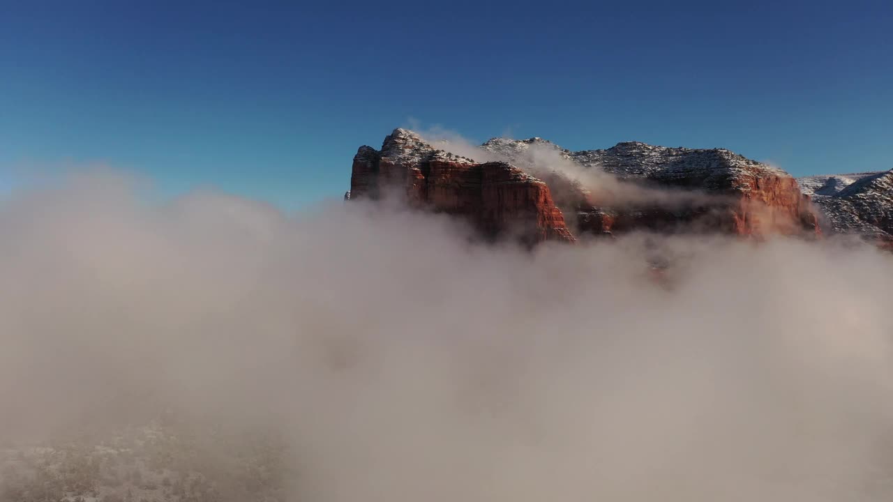 飞越云层，飞越亚利桑那州塞多纳的冬季仙境，暴风雪过后，红色的岩石被新雪覆盖。视频下载