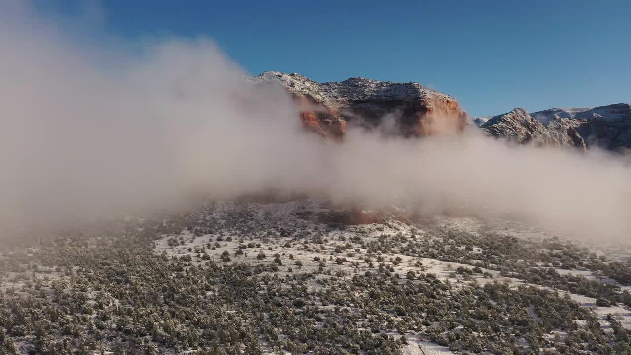 飞越云层，飞越亚利桑那州塞多纳的冬季仙境，暴风雪过后，红色的岩石被新雪覆盖。视频下载