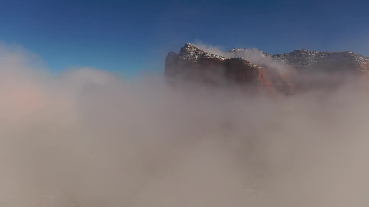 飞越云层，飞越亚利桑那州塞多纳的冬季仙境，暴风雪过后，红色的岩石被新雪覆盖。视频下载