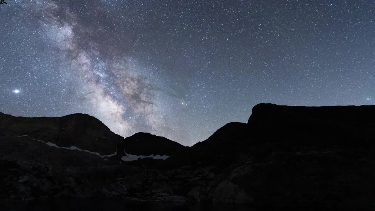 在晴朗的夜空下，银河从山上升起，这是延时拍摄的照片视频素材