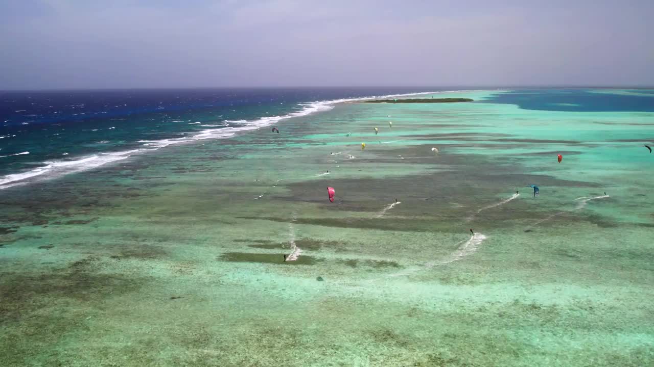 风筝冲浪者滑翔在清澈的绿松石海水塞瓦斯托波尔屏障在洛斯罗克，鸟瞰图视频素材