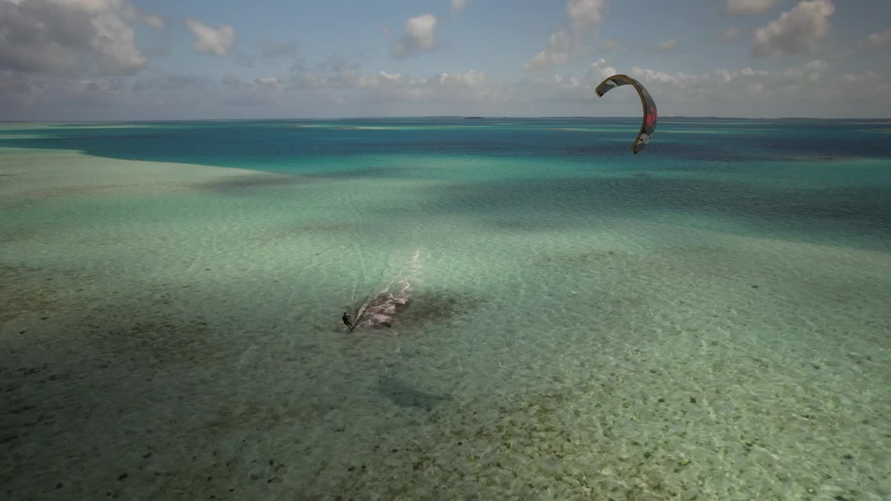 风筝冲浪滑翔在清澈的热带水域，无人机拍摄捕捉广阔的海洋美景，白天的场景视频素材