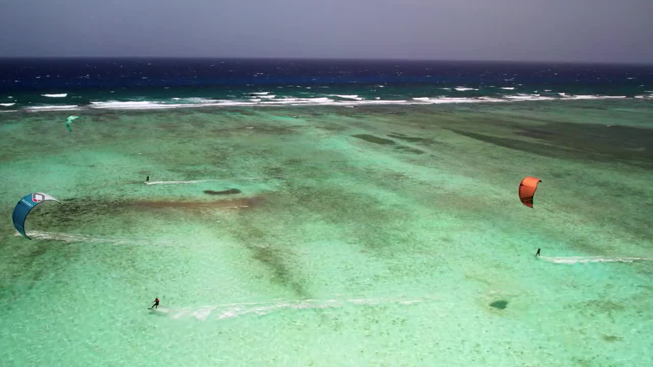 风筝冲浪者在大堡礁的碧绿海水上滑翔，充满活力和活跃的场景，阳光明媚的日子，鸟瞰图视频素材