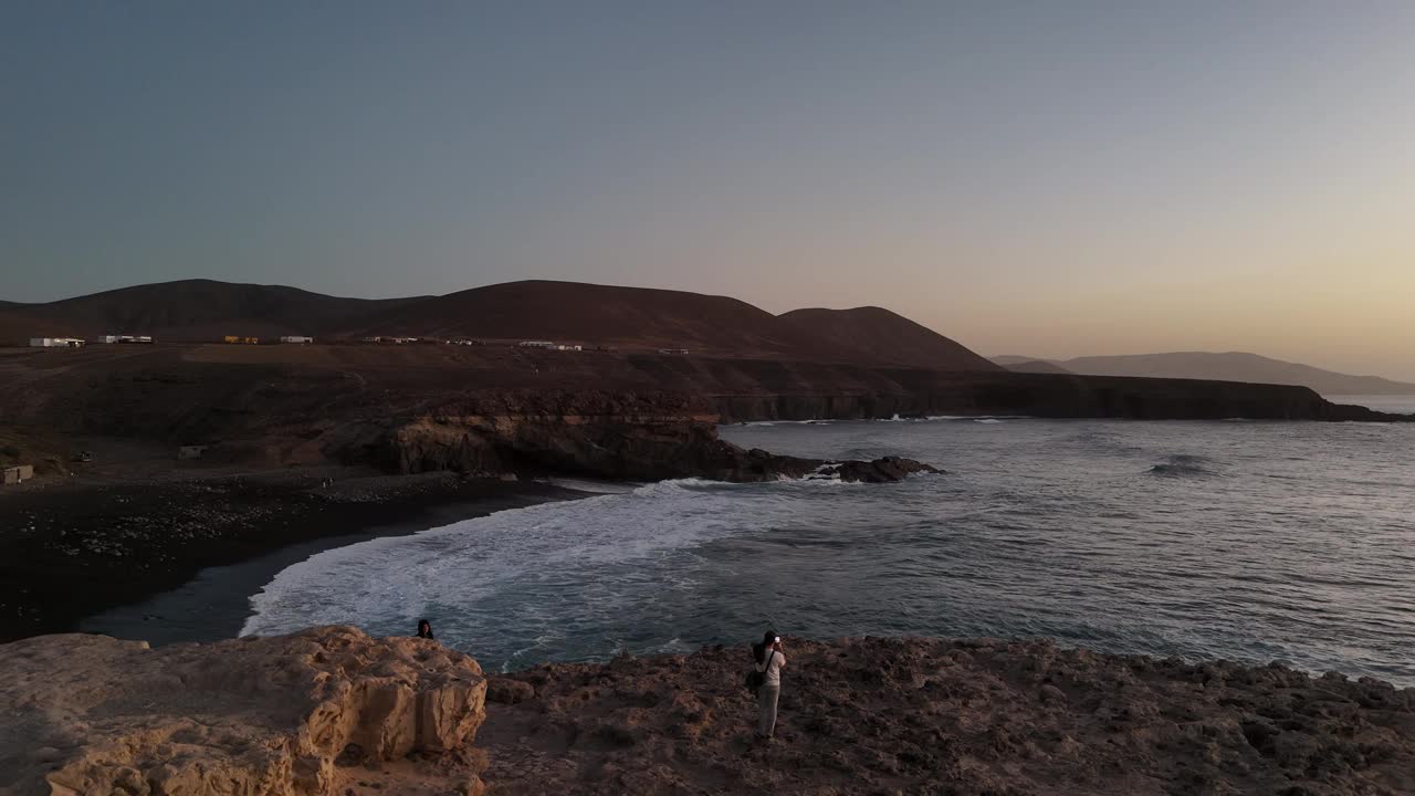 站在海边岩石海滩上的人视频素材