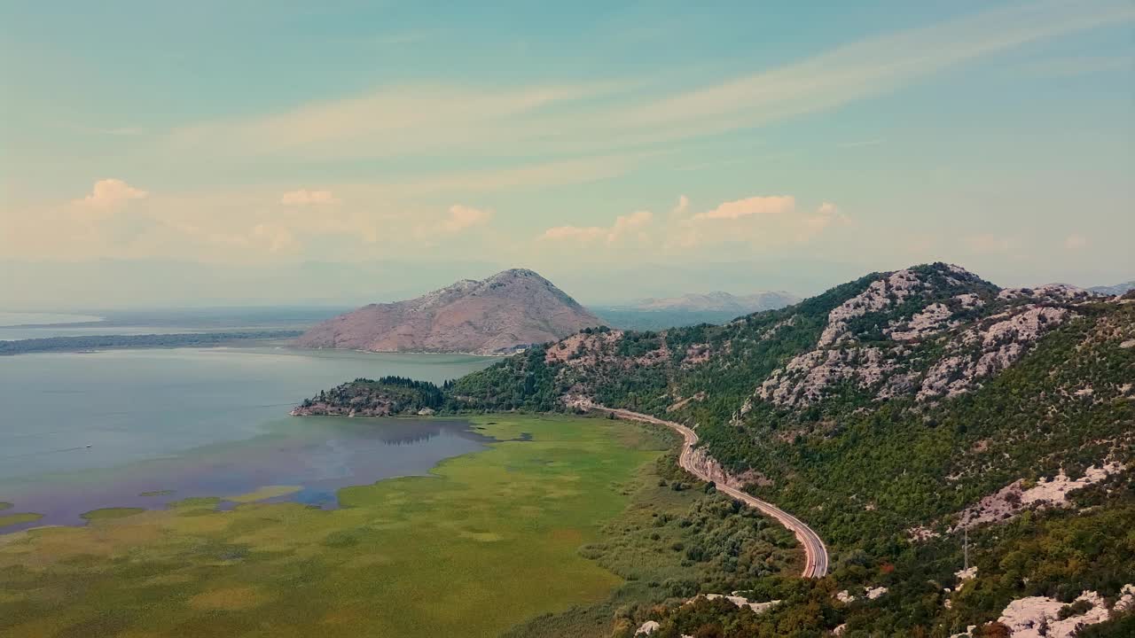 风景优美的山路沿着宁静的湖泊，提供雄伟的景观和自然景观，黑山斯卡拉德斯科湖视频素材