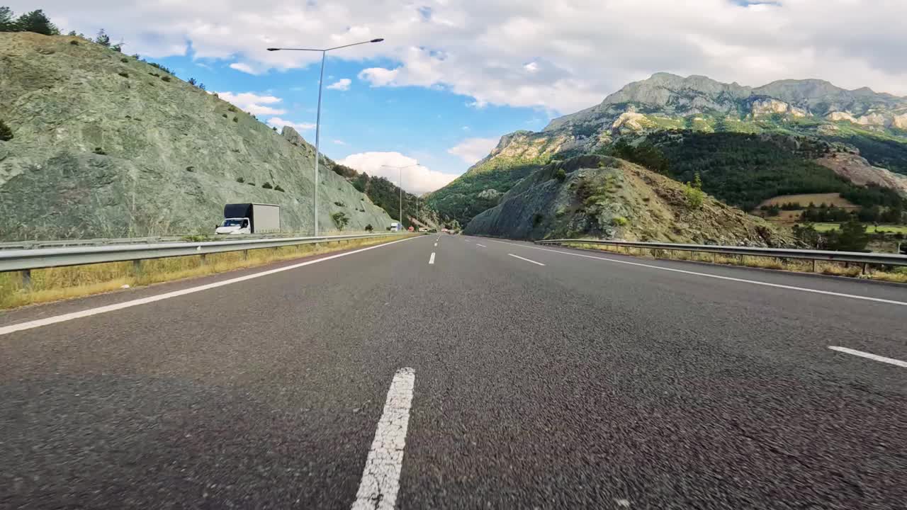 雄伟之旅:沿着山路行驶。一辆汽车在这条风景秀丽的公路上行驶，沿途有令人惊叹的山脉背景。视频素材