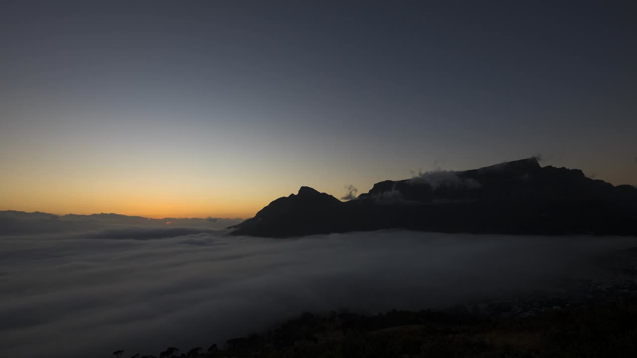 从山顶看到的太阳穿过云层升起的时间流逝视频下载