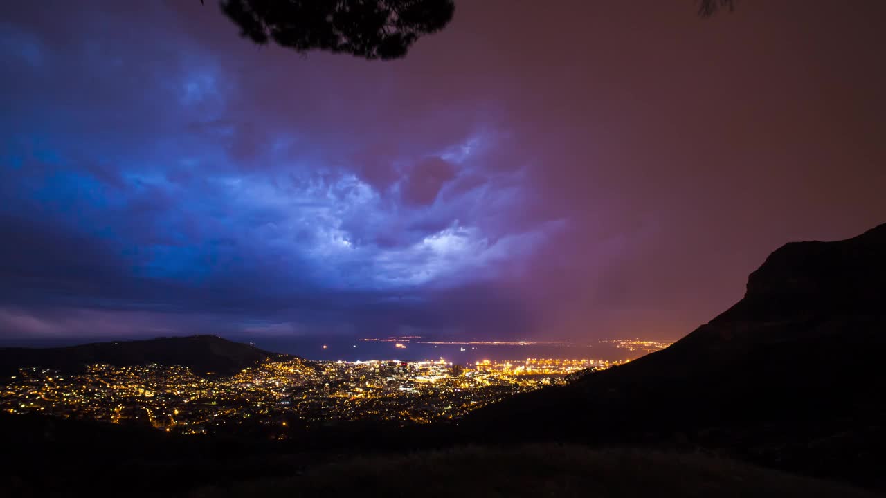 夜间雷暴在城市灯光上的时间流逝，前景为山视频素材